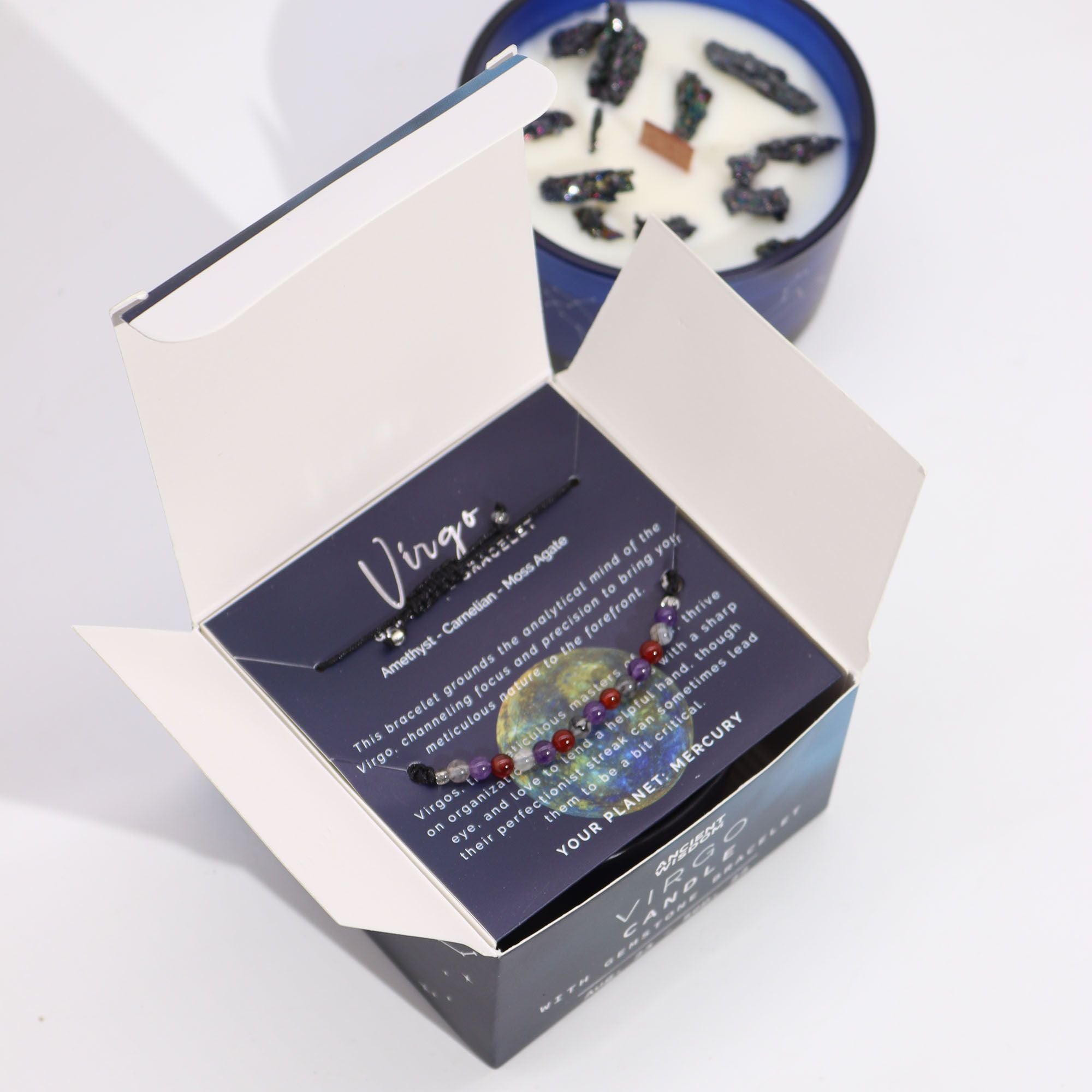 Boîte vierge ouverte contenant bracelet en pierres naturelles et bougie parfumée aux cristaux pour rituel bien-être