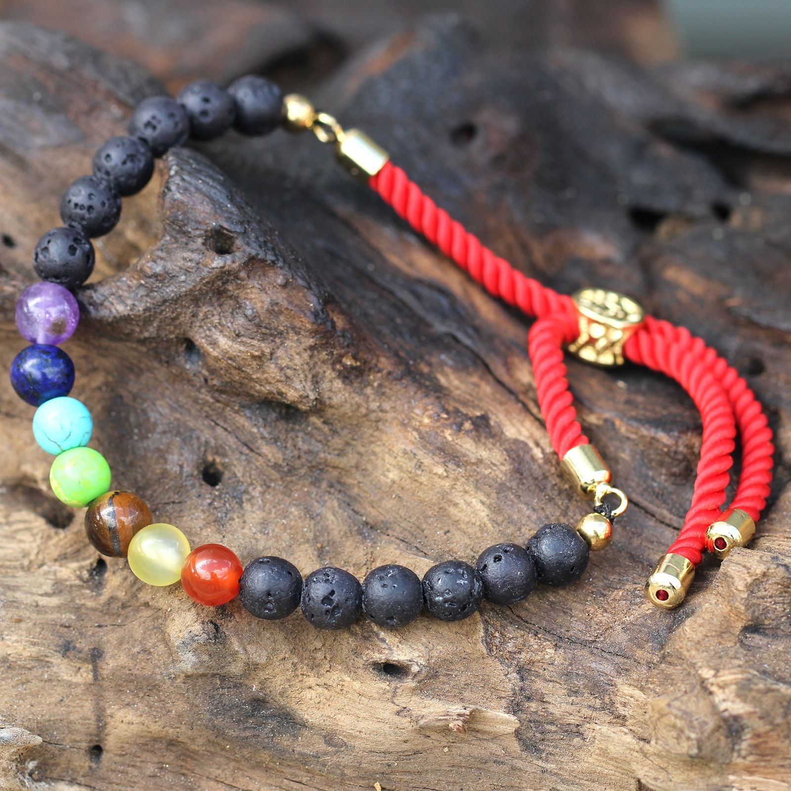 Bracelet en pierre de lave naturelle chakras posé sur bois, symbole de sérénité et énergie spirituelle