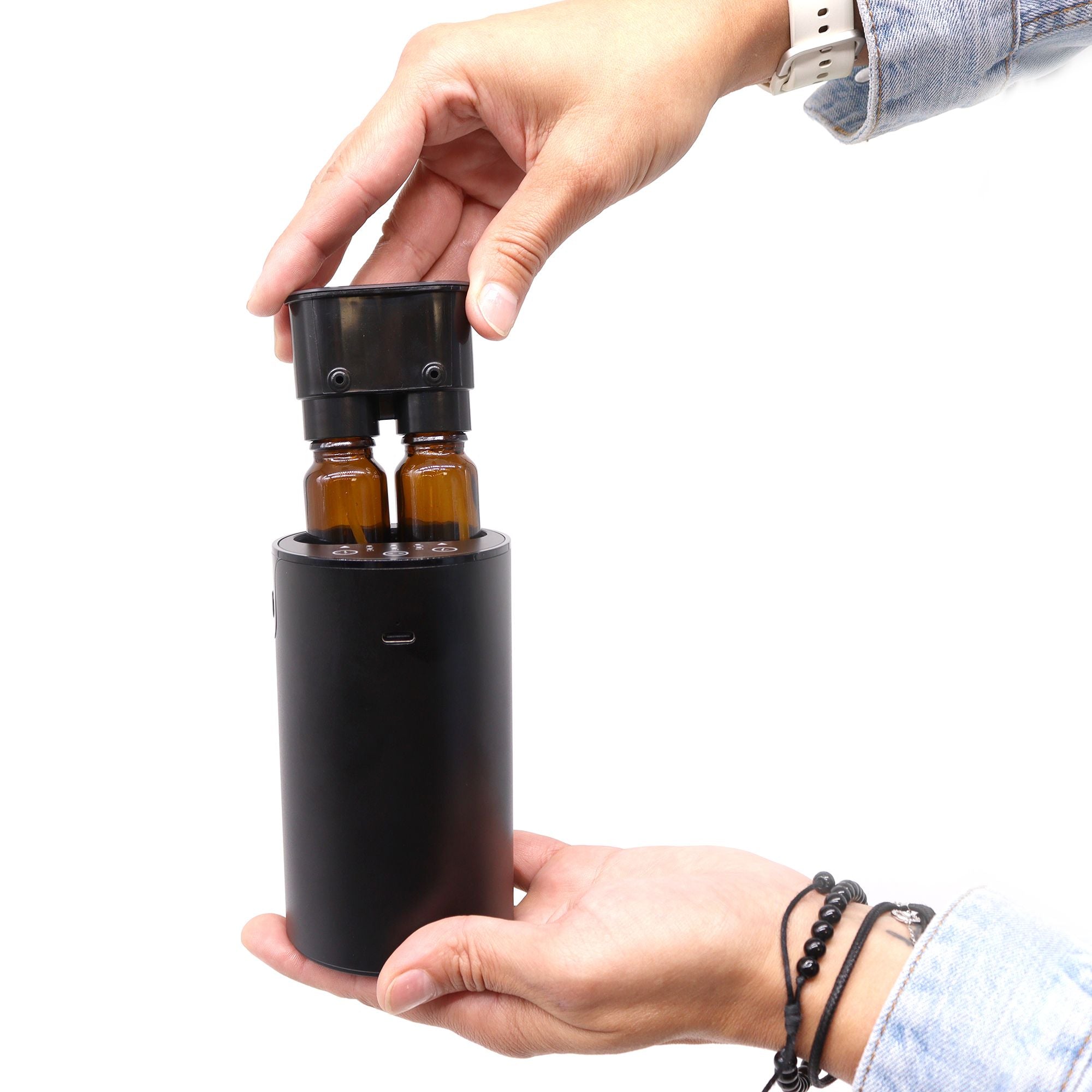 Main installant un flacon d’huile essentielle dans un diffuseur sans eau à nébulisation portable