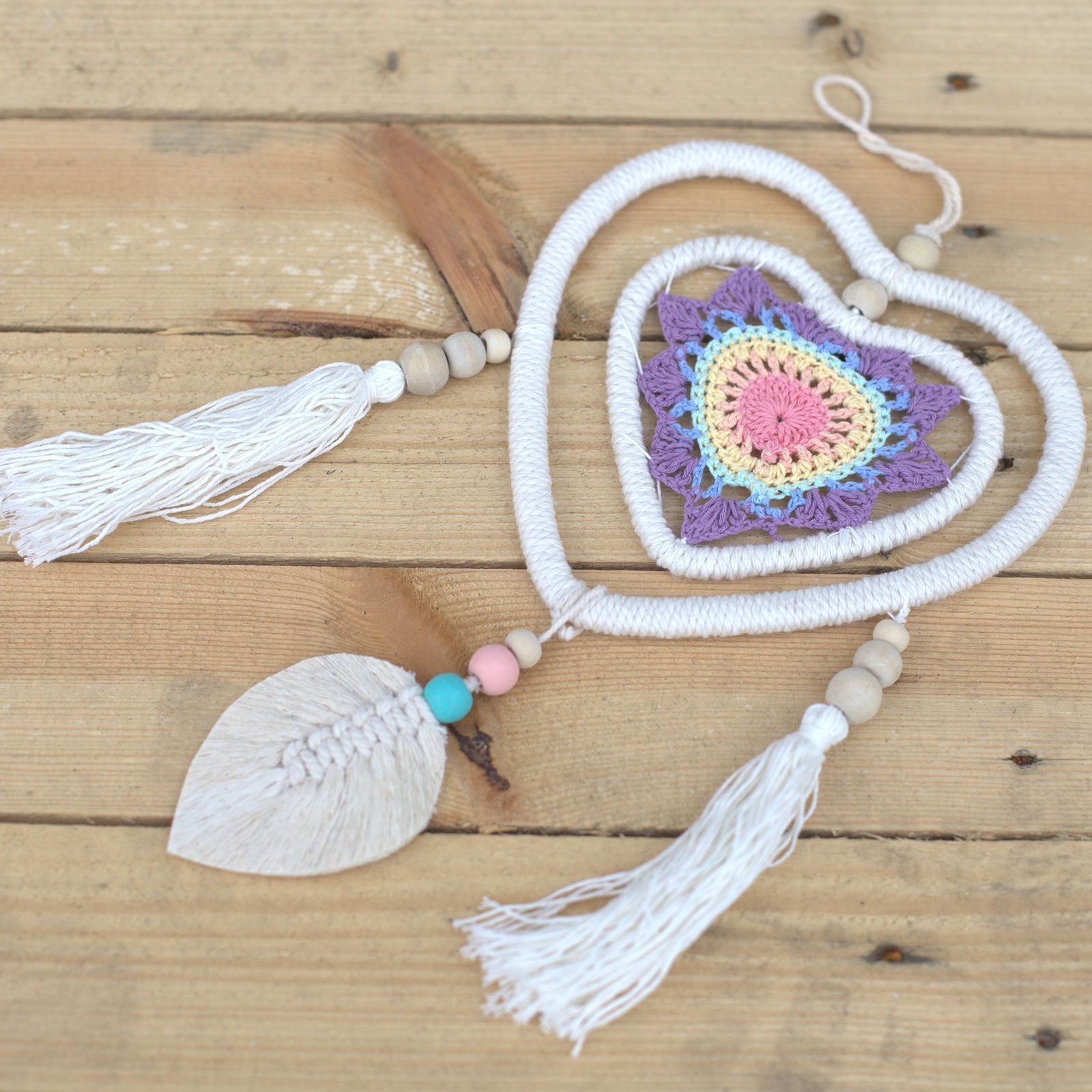 Détail du tissage d’un attrape-rêves multicolore avec perles et fils artisanaux