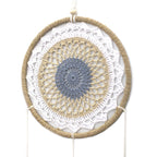 Détail du tissage d’un attrape-rêves marron esprit élémentaire avec motif circulaire et finitions artisanales