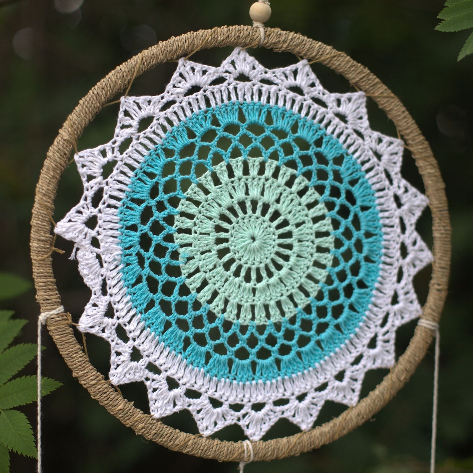 Détail du tissage turquoise d’un attrape-rêves esprit élémentaire avec motif circulaire harmonieux