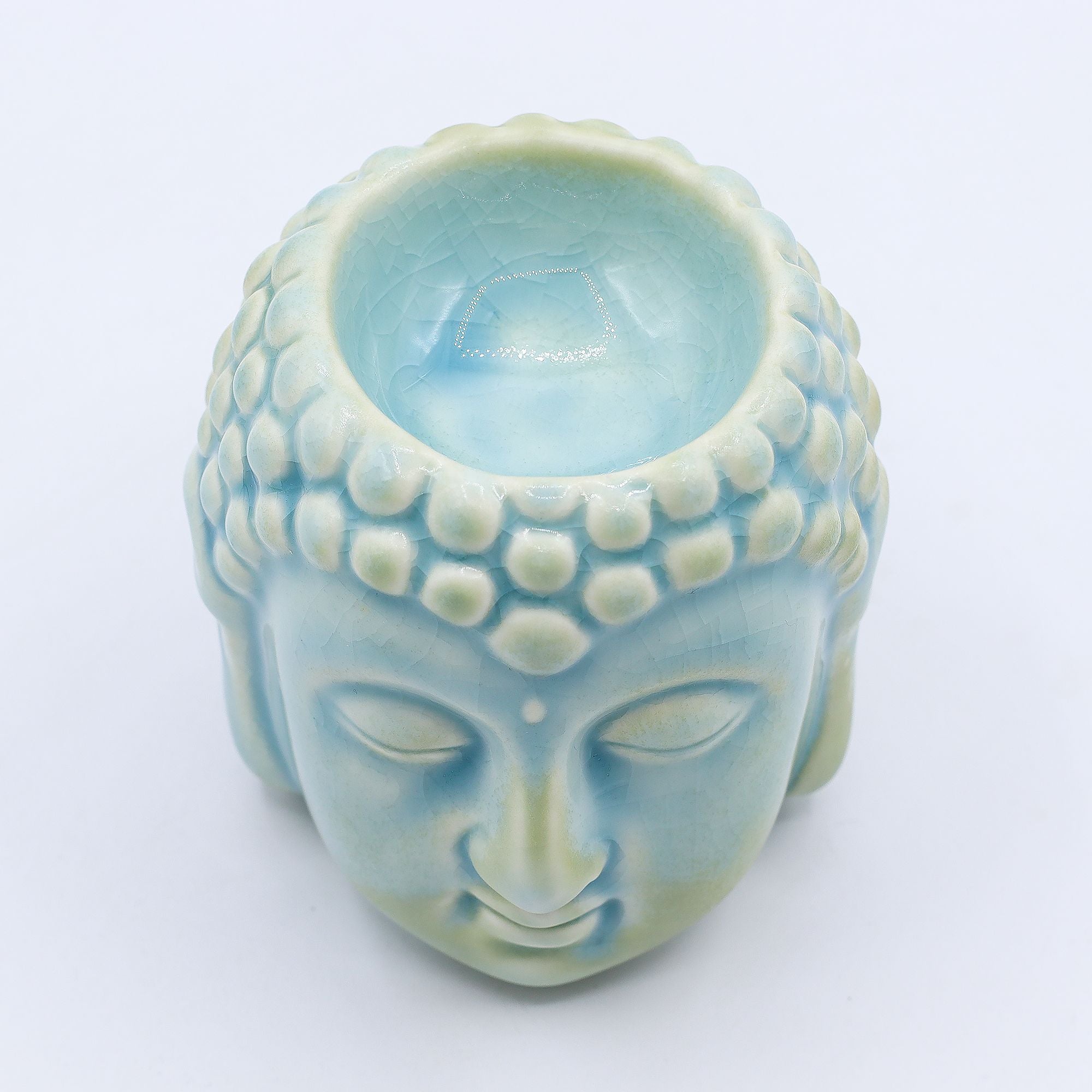 Vue du dessus du brûleur Bouddha bleu en céramique avec visage sculpté, décoration zen