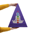 Coffret pyramidal violet de bols chantants chakras tenu en main avec illustration des 7 chakra