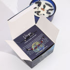 Boîte vierge ouverte contenant bracelet en pierres naturelles et bougie parfumée aux cristaux pour rituel bien-être