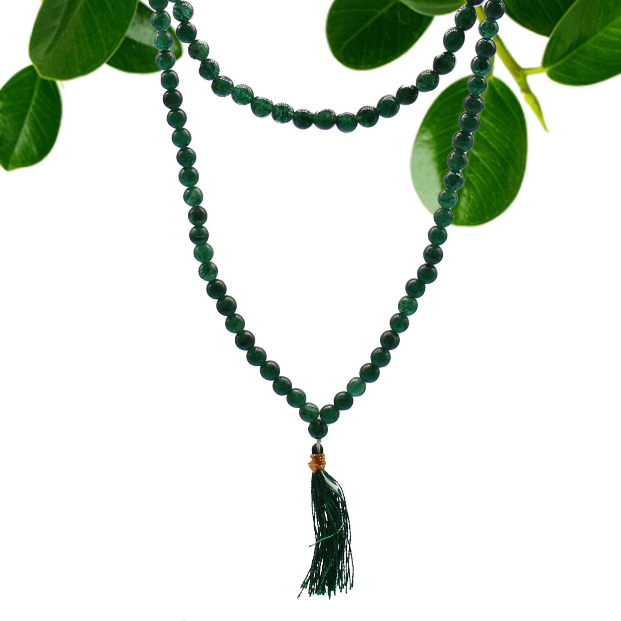 Collier mala 108 perles en pierre naturelle jade avec pompon vert, suspendu avec feuilles vertes en arriere plan, bijou spirituel pour meditation chakra et bien etre