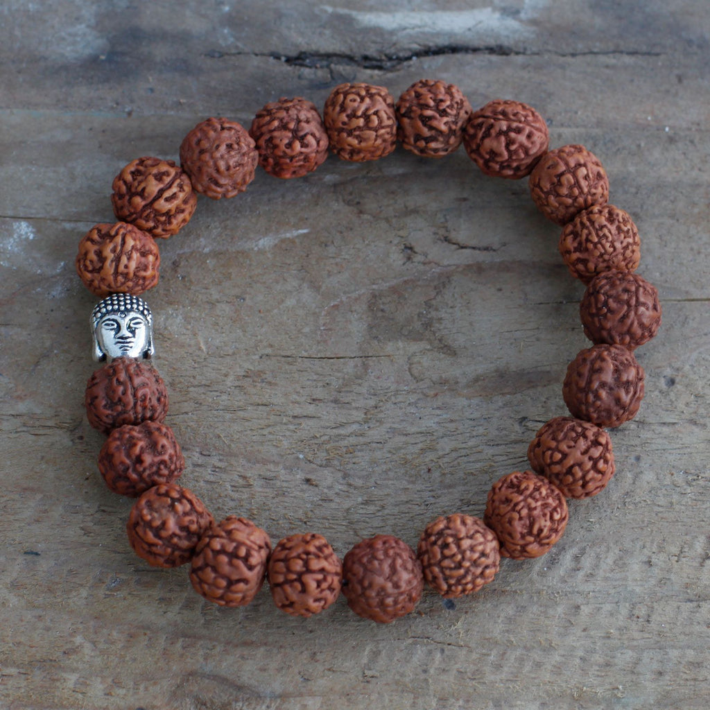 Gros plan sur les perles de rudraksha et la tête de Bouddha du bracelet mala