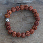 Gros plan sur les perles de rudraksha et la tête de Bouddha du bracelet mala