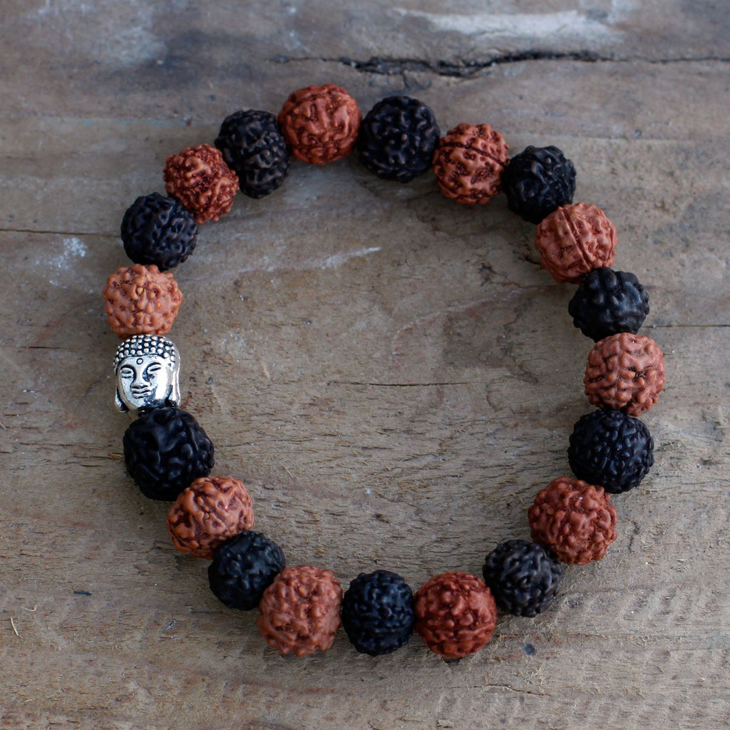 Gros plan sur les perles de rudraksha et la tête de Bouddha du bracelet mala noir marron