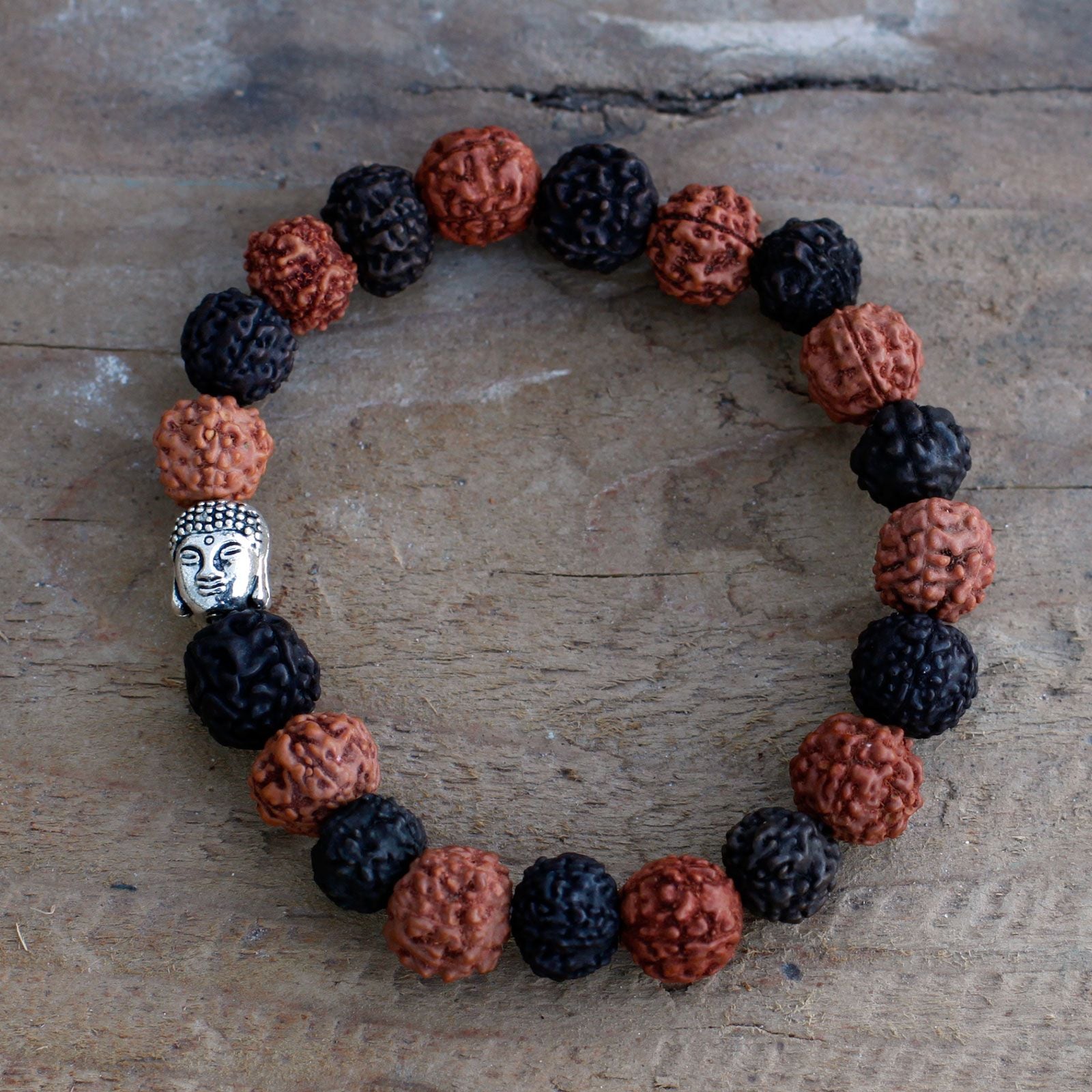 Gros plan sur les perles de rudraksha et la tête de Bouddha du bracelet mala noir marron