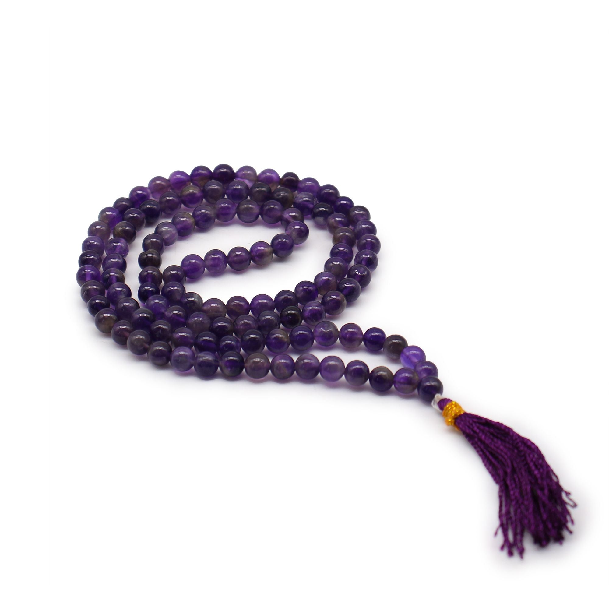 Mala 108 perles en pierre naturelle amethyste avec pompon violet, collier de meditation en perles rondes pose sur fond blanc, bijou spirituel pour yoga et relaxation