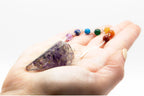 Pendule orgonite amethyste tenu en main pour radiesthésie, divination et travail énergétique