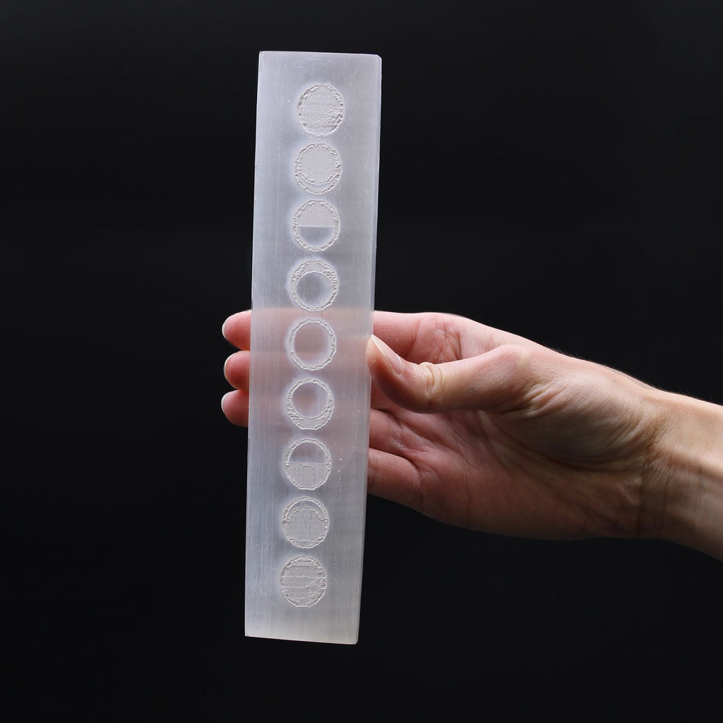 Plaque selenite cycles lunaires tenue en main pour recharger les pierres et renforcer l intuition