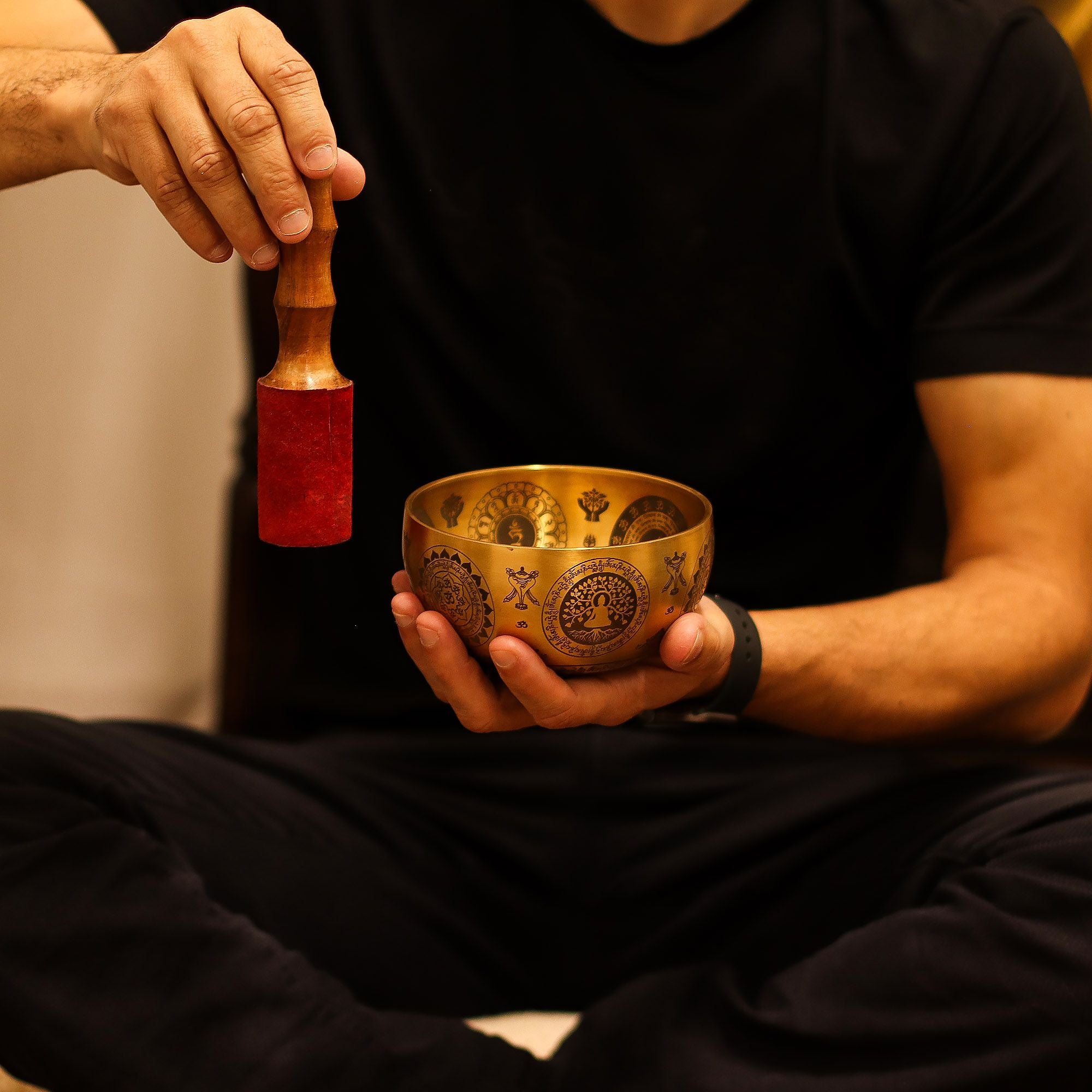 Personne utilisant un bol chantant tibétain avec maillet lors d’une séance de méditation et relaxation