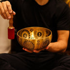 Personne utilisant un bol chantant tibétain avec maillet lors d’une séance de méditation et relaxation