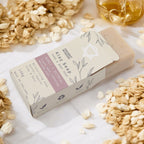 Savon naturel miel avoine exfoliation douce peau apaisée sortant du packaging et dans une ambiance naturelle