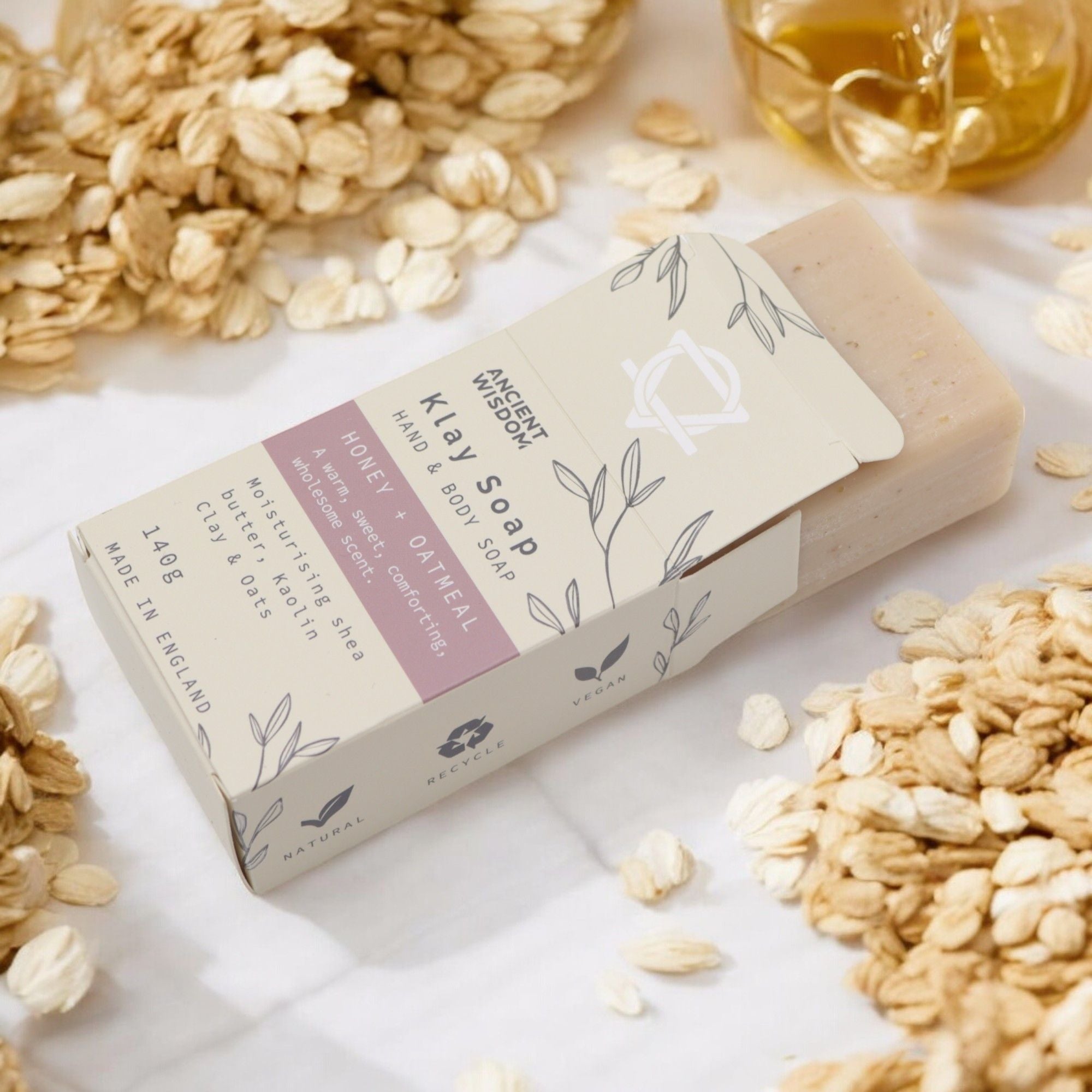 Savon naturel miel avoine exfoliation douce peau apaisée sortant du packaging et dans une ambiance naturelle
