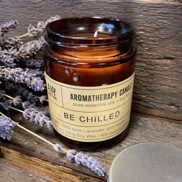 Bougie aromathérapie Be Chilled à base d’huile essentielle de lavande et fenouil, posée sur une surface en bois avec des brins de lavande, ambiance naturelle et relaxante