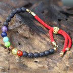 Bracelet en pierre de lave naturelle chakras posé sur bois, symbole de sérénité et énergie spirituelle