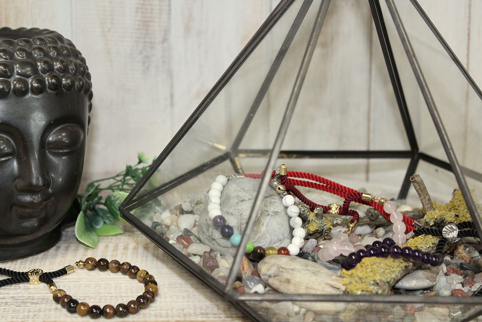 Bracelets en pierres naturelles disposés dans une décoration spirituelle avec statue de Bouddha et cristaux