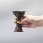 Calice rituel en cuivre tenu en main avec symbole triple lune, utilisé lors de cérémonies et rituels spirituels