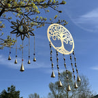 Carillon arbre de vie suspendu en extérieur dans un jardin, créant une ambiance apaisante et harmonieuse