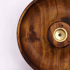 gros plan sur gravure bouddha en méditation sur un porte encens artisanal en bois naturel