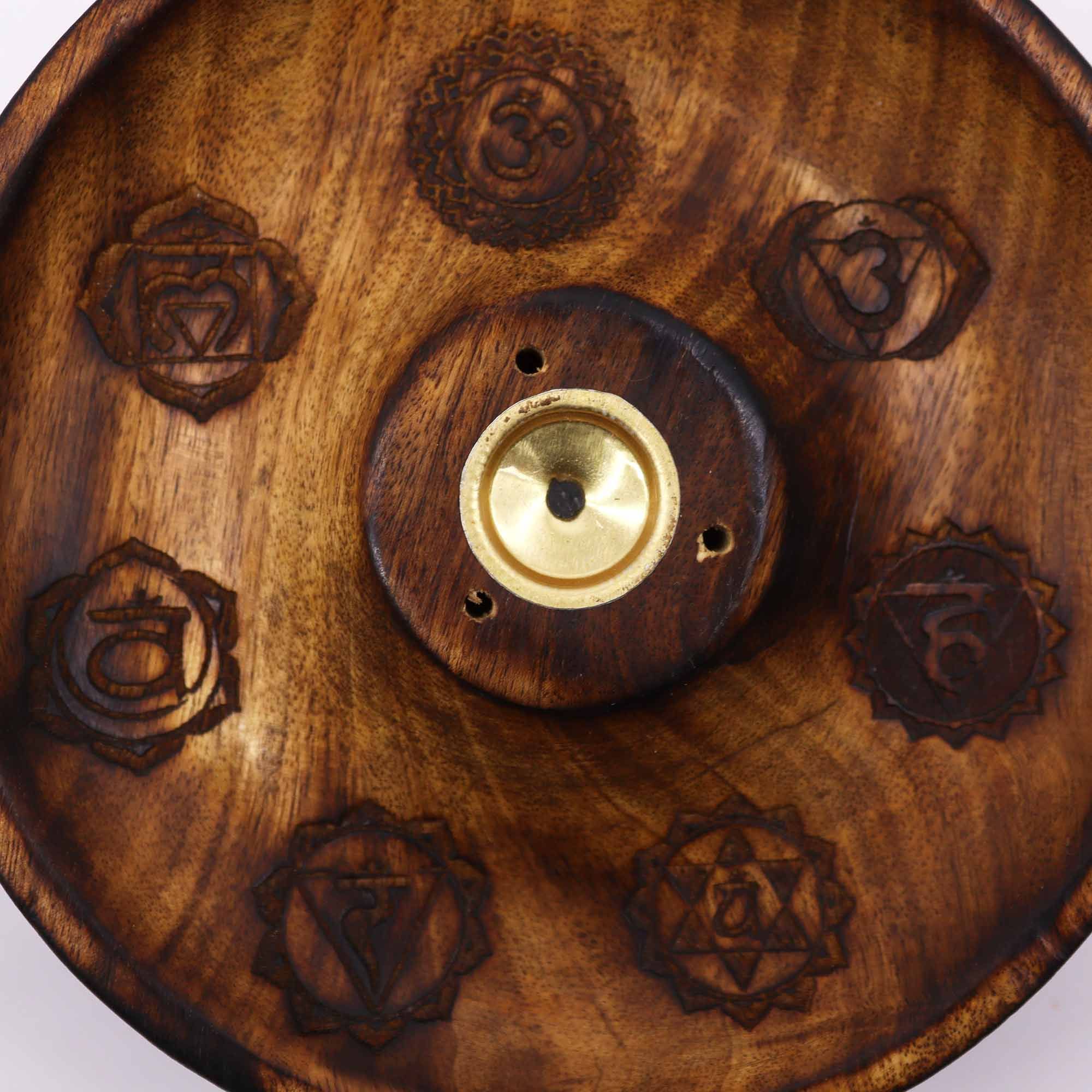 gros plan sur gravures des symboles des 7 chakras sur un porte encens artisanal en bois naturel