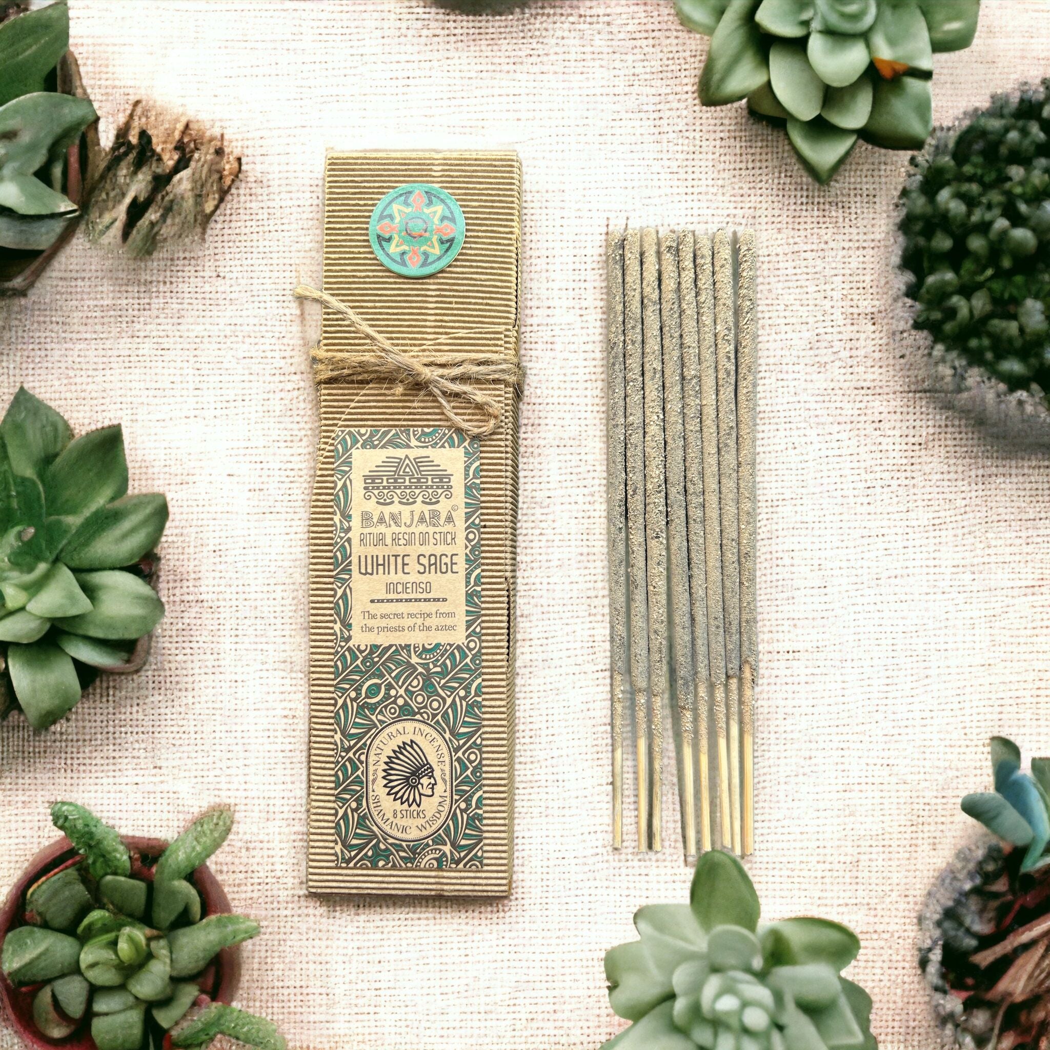 Encens résine sur bâton Sauge blanche Banjara avec boîte écologique, bâtons d’encens verts et plantes naturelles disposées sur fond terreux