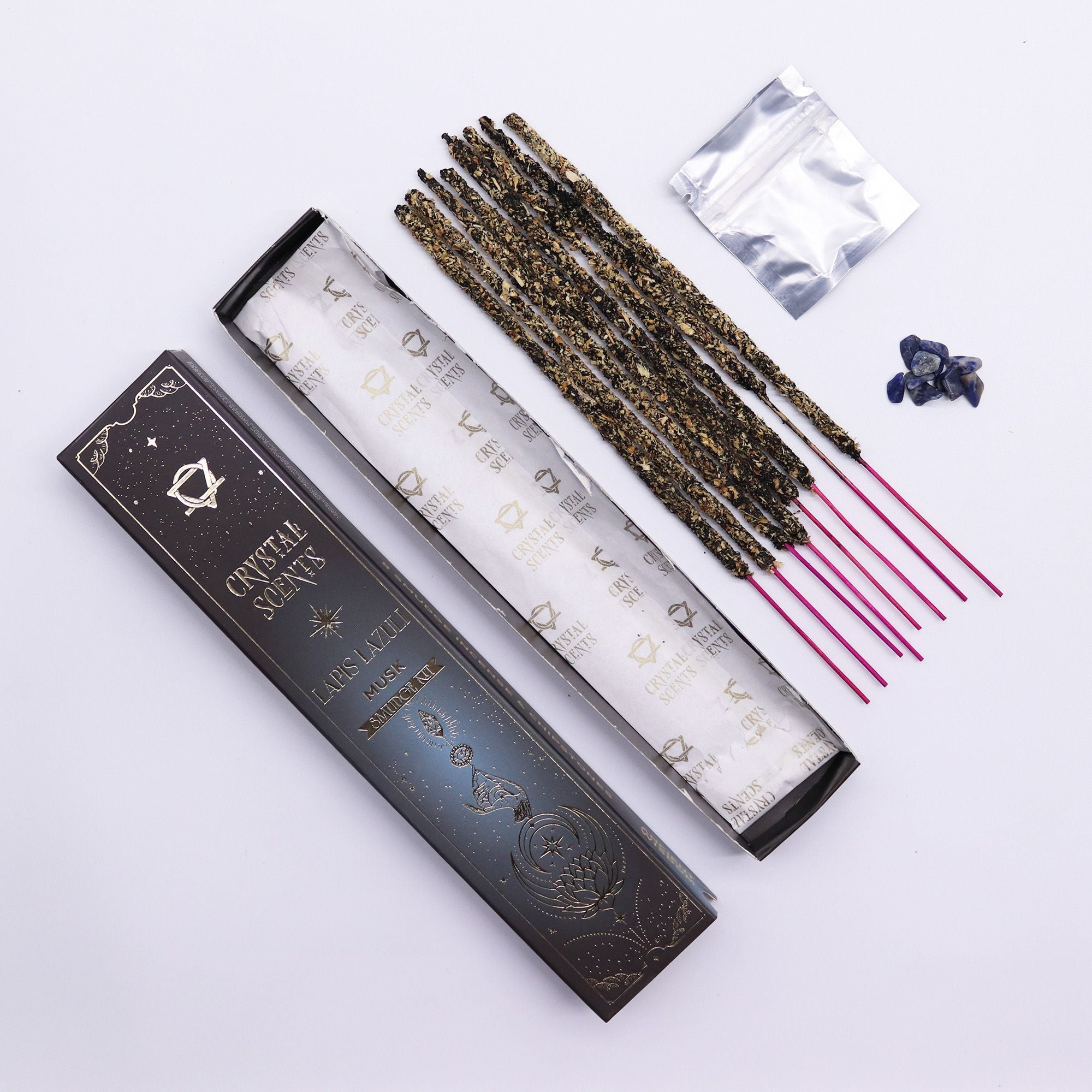Bâtons d’encens smudge musc avec pierres de lapis lazuli et packaging ouvert présenté sur fond clair