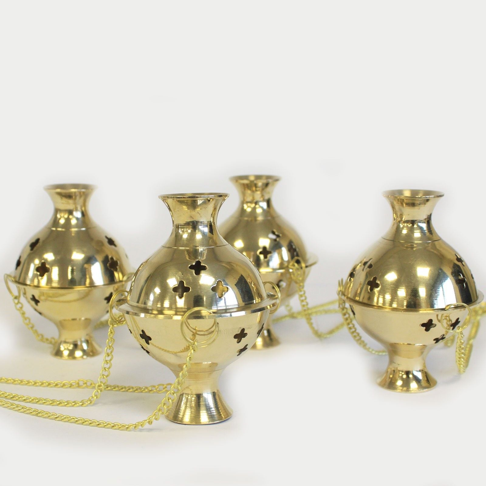 plusieurs encensoirs suspendus en laiton avec chaînes montrant le design traditionnel du brûleur d encens
