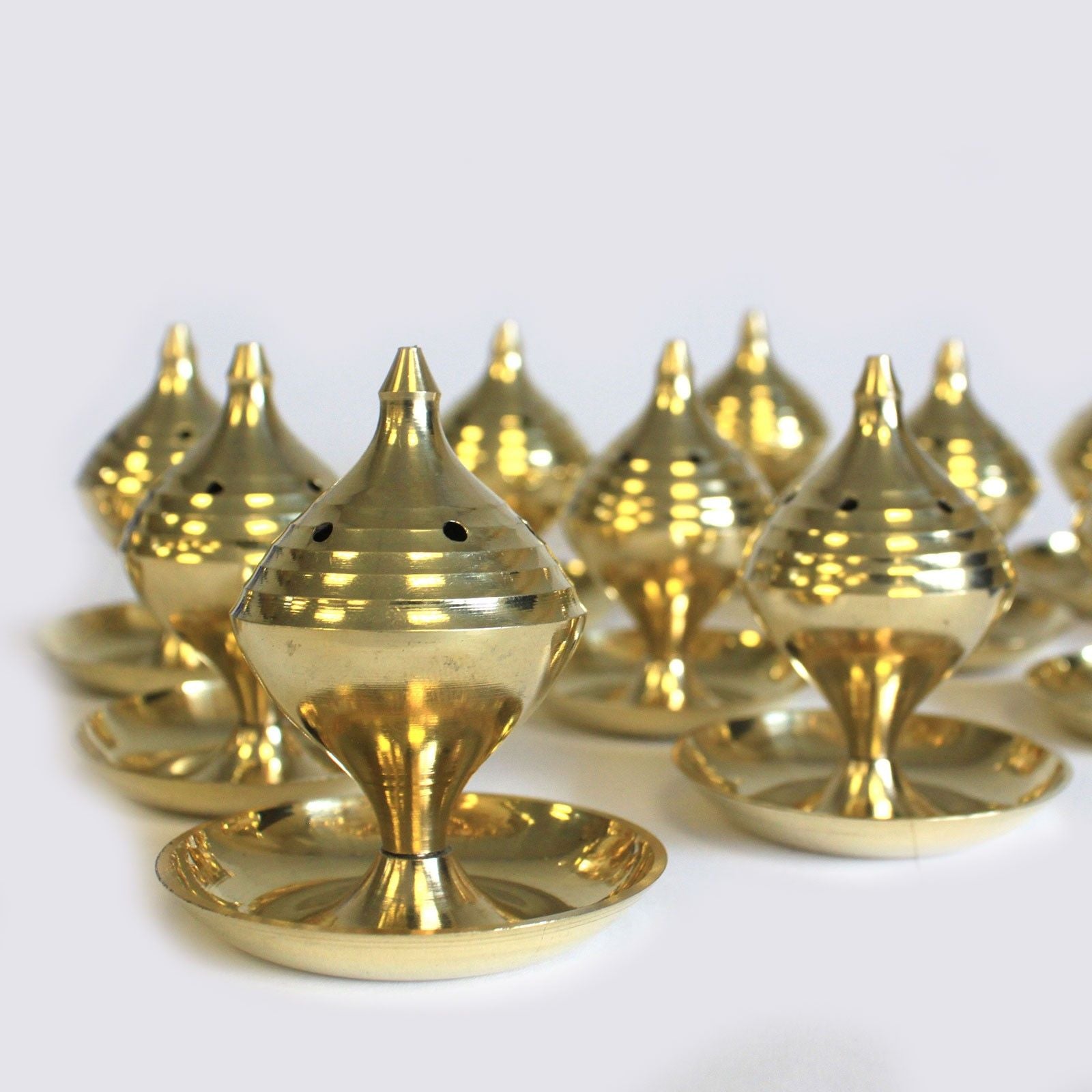 plusieurs encensoirs en laiton de taille moyenne alignés montrant leur design traditionnel et leur finition dorée