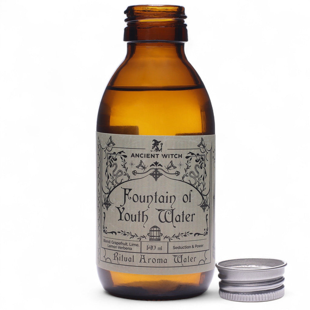 Eau rituelle Fontaine de jouvence en flacon ambré avec bouchon posé à côté, utilisée pour les rituels énergétiques et la revitalisation