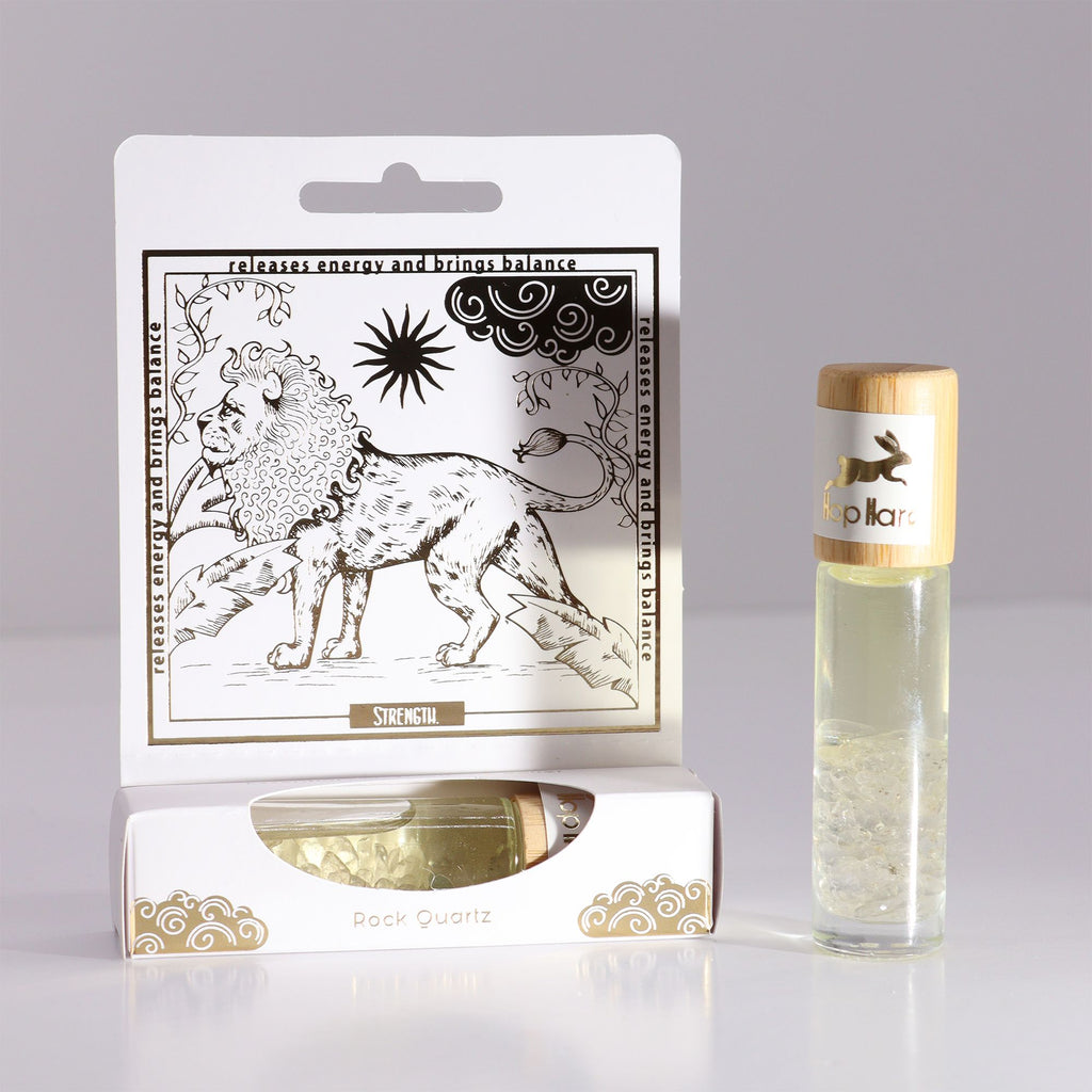 Roll-on Le lion aux huiles essentielles et pierre naturelle de quartz posé sur son coffret tarot
