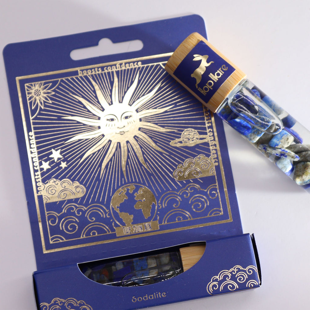 Roll-on Le soleil aux huiles essentielles et pierre naturelle de sodalite posé sur son coffret tarot.