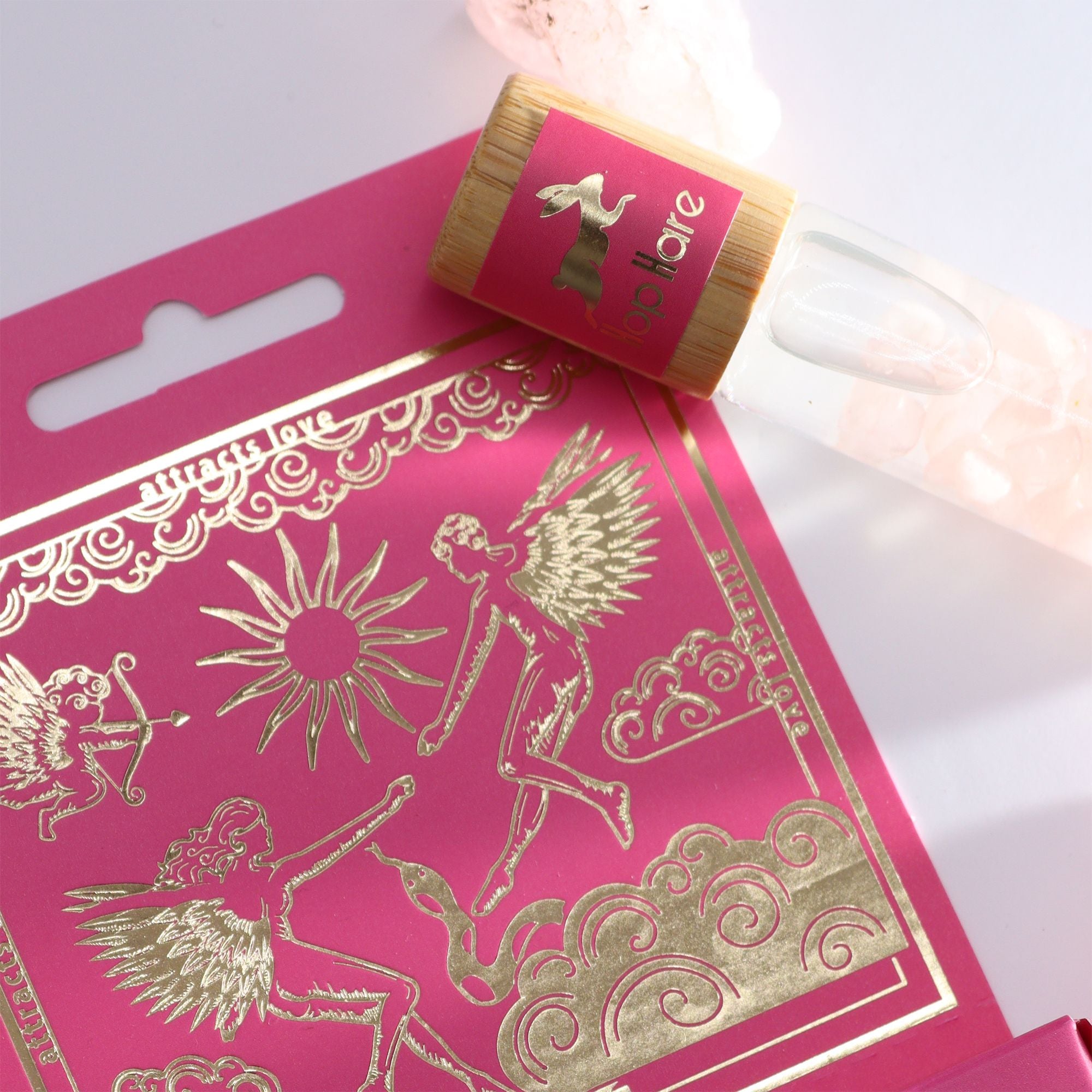 Roll-on Les amoureux aux huiles essentielles et pierre naturelle de quartz rose posé sur son coffret tarot.