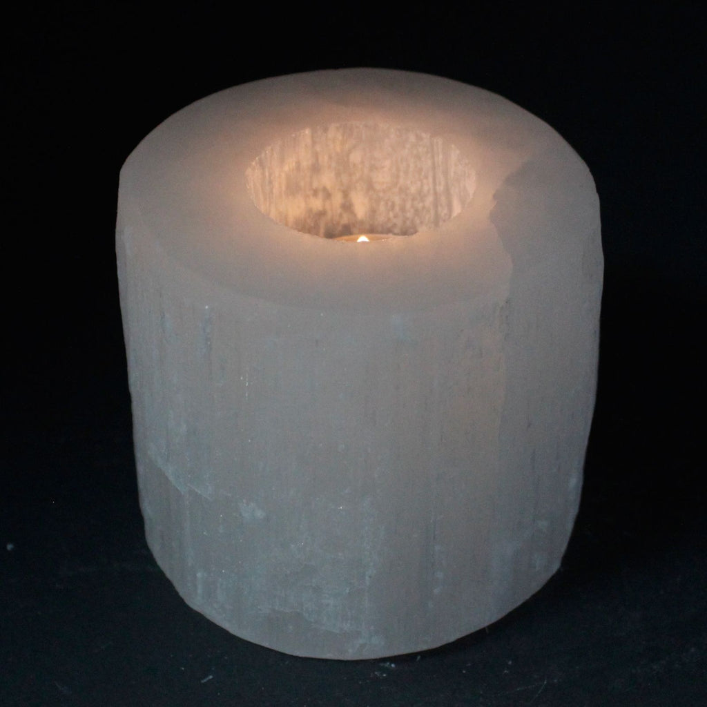 Photophore en selenite forme cylindre avec bougie allumee diffusant une lumiere douce et harmonieuse