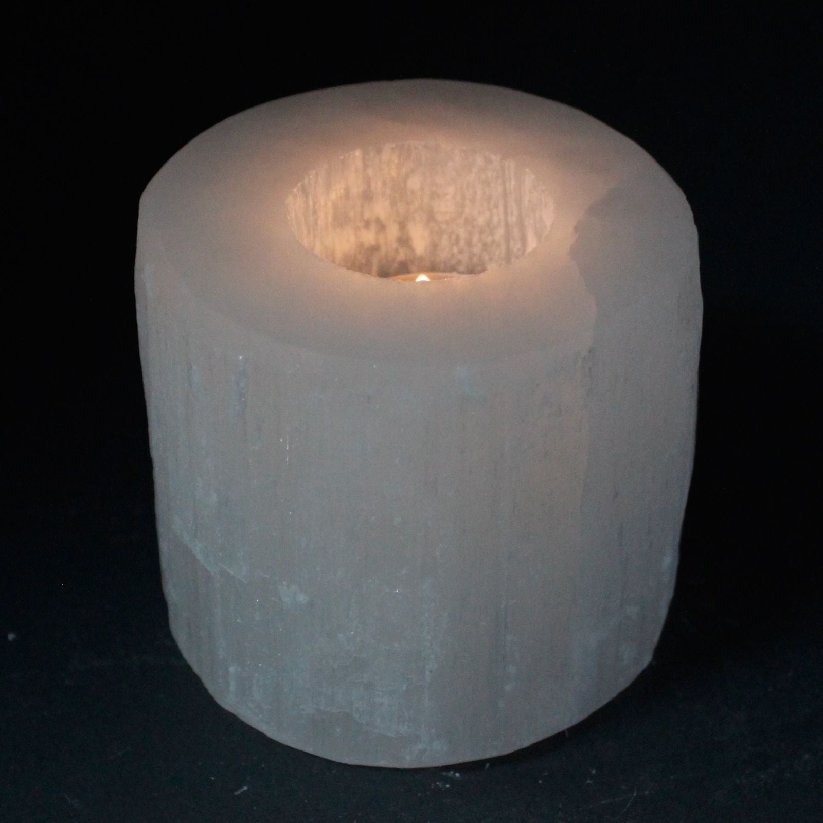 Photophore en selenite forme cylindre avec bougie allumee diffusant une lumiere douce et harmonieuse