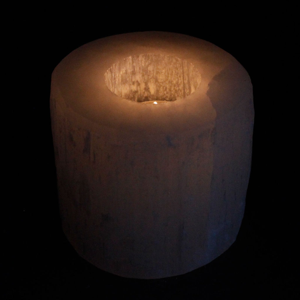 Photophore en selenite avec flamme de bougie creant une ambiance chaleureuse et apaisante