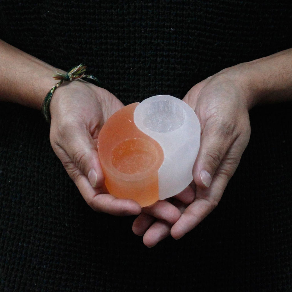 Photophore selenite yin yang tenu en main illustrant son design symbolique et son format pratique