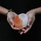 Photophore selenite yin yang tenu en main illustrant son design symbolique et son format pratique