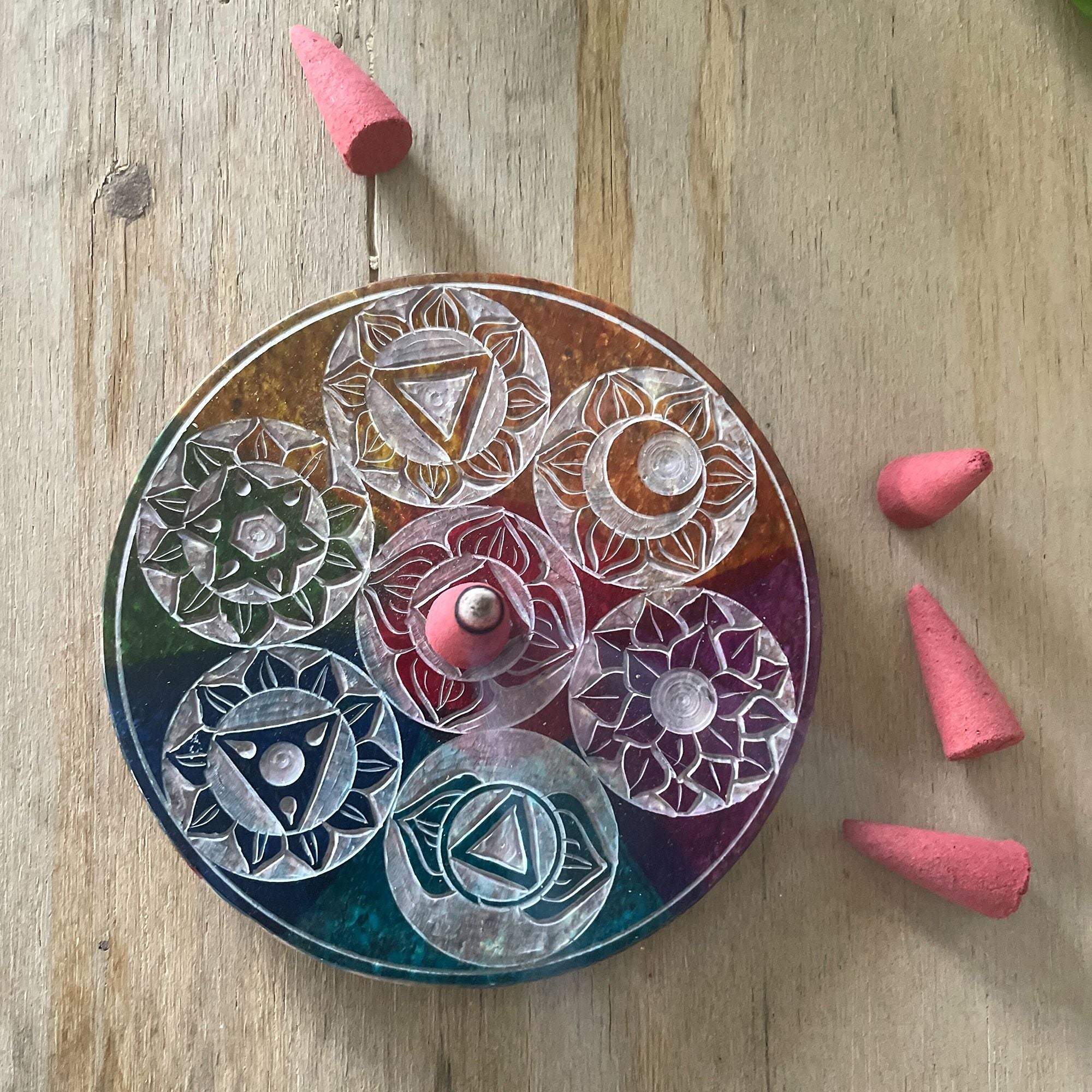 Porte-Encens 7 Chakras en pierre posé sur table bois avec cônes d’encens, parfait pour espace méditation et rituel quotidien.