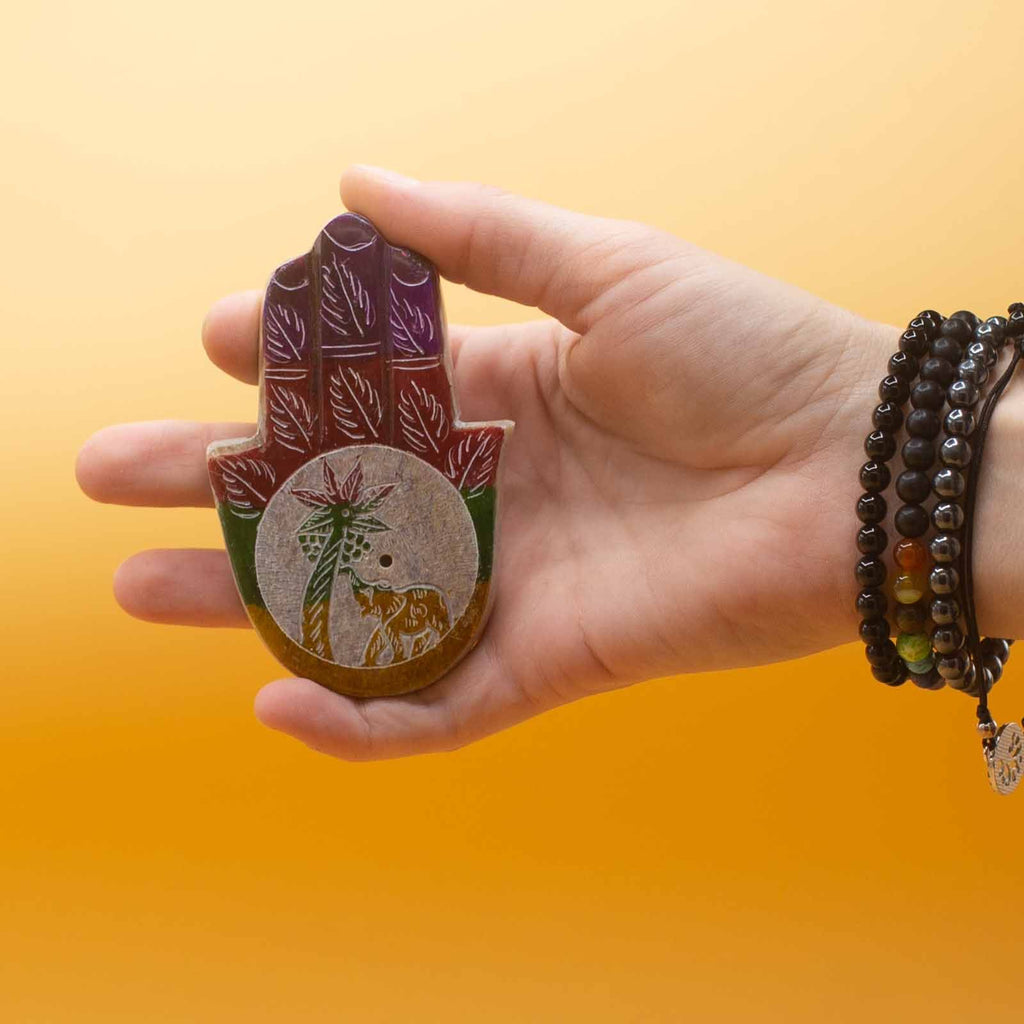 Petit porte-encens Hamsa 9x6 cm en pierre tenu en main, idéal pour autel personnel et pratique de méditation.