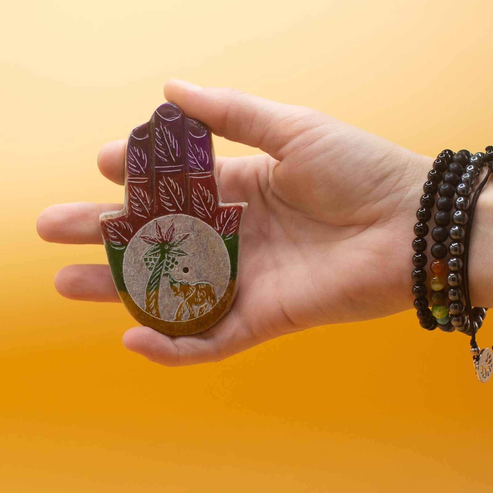 Petit porte-encens Hamsa 9x6 cm en pierre tenu en main, idéal pour autel personnel et pratique de méditation.