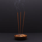 porte encens en bois naturel avec trois bâtons d encens allumés diffusant une fumée apaisante créant une atmosphère méditation et relaxation