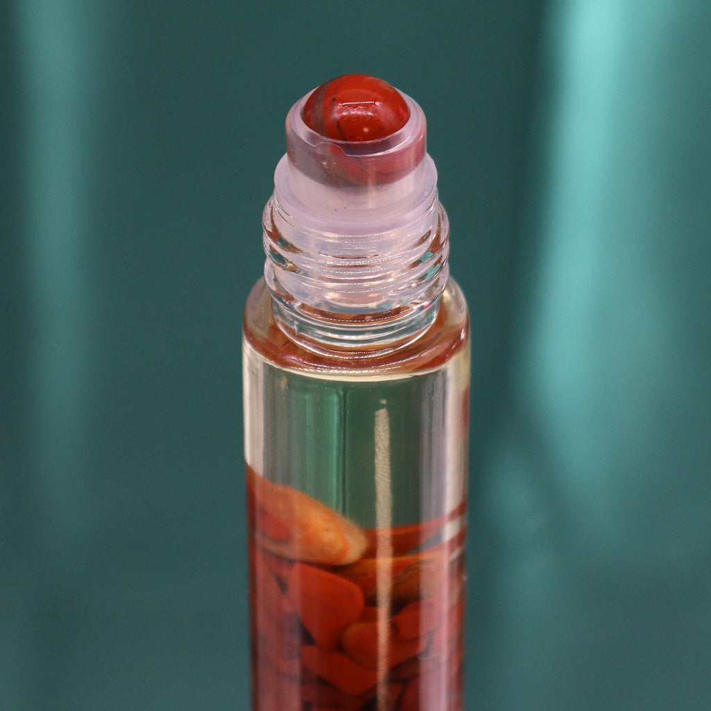 Roll-on aux huiles essentielles avec bille applicatrice et pierre naturelle de jaspe rouge.