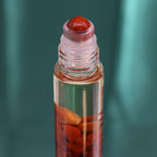 Roll-on aux huiles essentielles avec bille applicatrice et pierre naturelle de jaspe rouge.