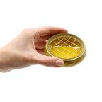 Main tenant un brûleur d’encens jaune au charbon en laiton, utilisation lors d’un rituel énergétique chakra plexus solaire